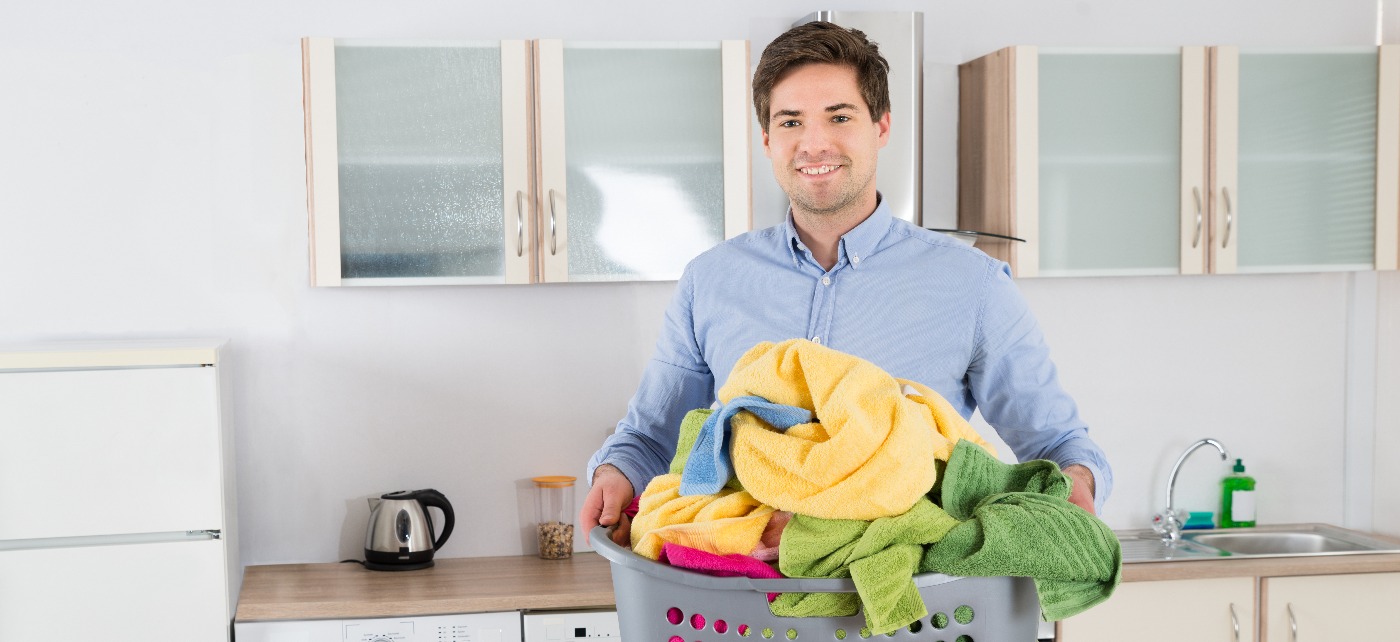 un homme qui porte une manne remplie de linge 