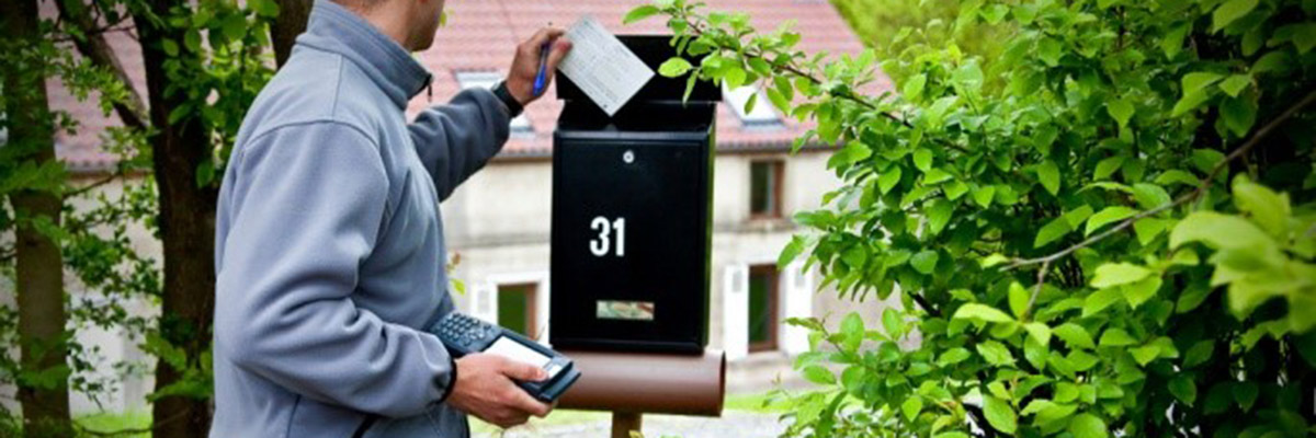 un collaborateur ORES dépose un avis de passage dans une boite aux lettres