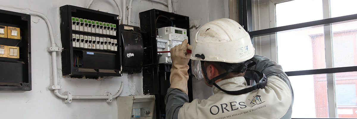 technicien ORES en train de travailler sur un compteur électrique