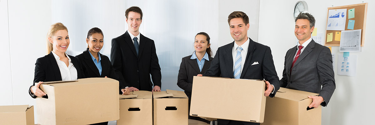 une équipe d'hommes et de femmes en costume transportent des caisses de déménagement