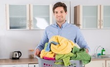 un homme qui porte une manne remplie de linge 